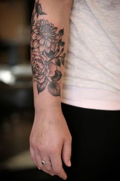 a woman with a flower tattoo on her arm