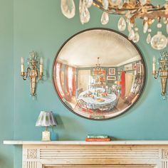 a fireplace with a mirror on the wall above it and a table in front of it