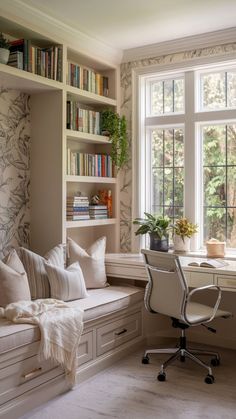 a window seat in front of a book shelf filled with books and plants next to a window