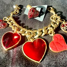 Pilgrim Skanderborg Gold Tone Link Brass Bracelet With Red Leatherette, Swarovski Red Crystals And Resin Heart Charm Bracelet, With Matching Swarovski Red Crystal Heart Ring, Adjustable. Heart-shaped Bracelet For Valentine's Day Party, Heart Bracelet For Valentine's Day Party, Valentine's Day Heart Bracelet For Party, Trendy Red Heart Bracelet As A Gift, Metal Heart Bracelet For Valentine's Day Party, Trendy Red Heart Bracelet For Gift, Trendy Red Heart Bracelet As Gift, Heart-shaped Gold Jewelry For Fashion, Valentine's Day Metal Heart Bracelet For Party