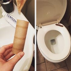 a person holding a roll of toilet paper in front of a toilet with the lid up