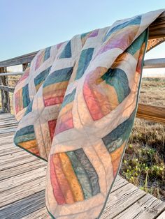 a quilt is draped on a wooden deck