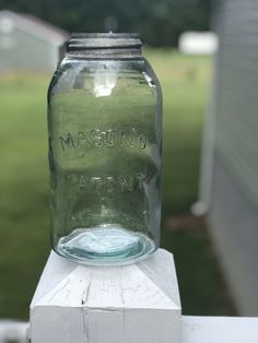 a mason jar sitting on top of a white fence post