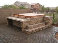 a hot tub sitting on top of a brick patio