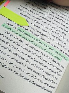 someone is writing on a book with green and yellow highlighters next to it,