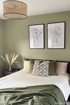 a bedroom with two pictures above the bed