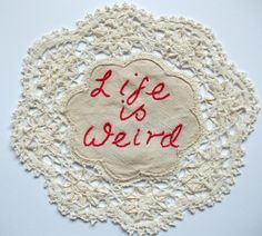 a doily with the words i life is weird written on it