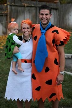 a man and woman dressed up as flintman and his wife with a baby in their arms