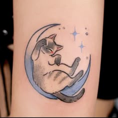 a cat is sitting on the moon tattoo