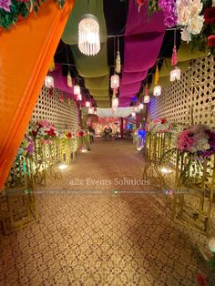 an aisle decorated with flowers and lanterns