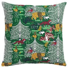 a green pillow with animals and trees on it