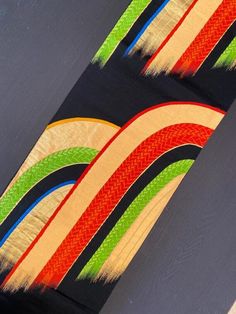 the back end of a skateboard with multicolored stripes on it