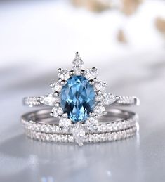 a blue and white diamond ring set on top of each other with diamonds around it