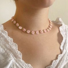 "Handmade baby pink beaded daisy/flower necklace. Beads are glass and hardware is 14kt gold-filled. Necklace length is approximately 13.5\" (34 cm)  and with hardware, approximately 14.5\" (37 cm). Intended fit for necklace is at base of neck, not choker-length." Pink Flower Necklaces With Tiny Beads, Pink Flower Necklace With Tiny Beads, Pink Flower-shaped Necklace With Tiny Beads, Cute Pink Necklaces With Tiny Beads, Spring Pink Beaded Necklace, Handmade Pink Dainty Beaded Necklaces, Pink Floral Beaded Chain Jewelry, Pink Flower-shaped Beaded Chain Jewelry, Delicate Pink Jewelry With Colorful Beads