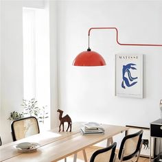 a dining room table with two chairs and a lamp on the wall next to it