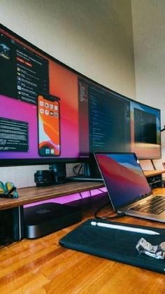 a laptop computer sitting on top of a wooden desk next to a monitor and speakers