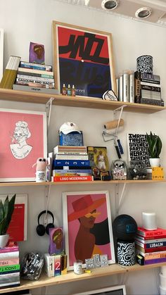 shelves with books and pictures on them in a room