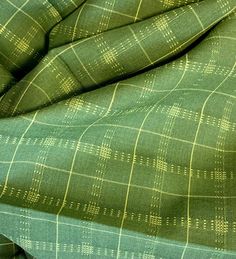 a green and white checkered fabric with yellow lines on the top, as if it were woven into something else