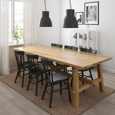 a dining room table with black chairs and an area rug