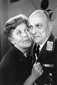 an old man and woman are posing for a photo in front of a mirror together