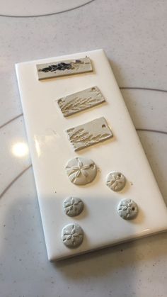 a white board with buttons on it sitting on top of a marble counter next to a pair of scissors