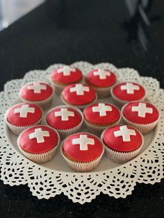 cupcakes with red frosting and white crosses on them are arranged in a circle