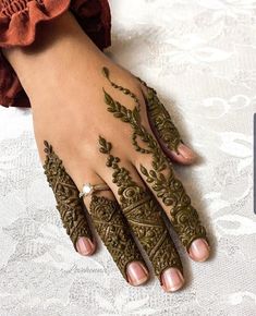 a woman's hand with henna tattoos on it