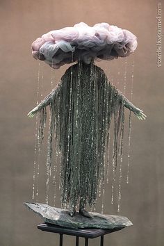 a sculpture is covered in water droplets and has two hands on it's head