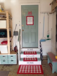 the front door is decorated with red and white checkered rugs on the steps