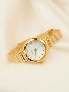 This dainty round face watch, features a slim gold mesh wrist band. Slim in style, this watch is perfect to add to a wrist stacked with bracelets or alone for a sophisticated style. Women Gold Watches Classy Elegant, Dainty Wrist Watch, White Dress Boots, Circle Face, Statement Earrings Gold, Golden Watch, Wrist Stacks, Timeless Watches, Dainty Necklaces