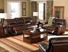 a living room filled with brown furniture and pillows