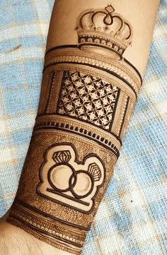 a person's arm with a henna on it and a crown on top