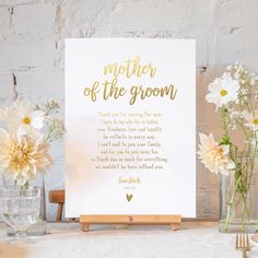 a mother of the groom card sitting on top of a table next to some flowers