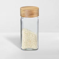 a glass jar filled with rice and a wooden lid