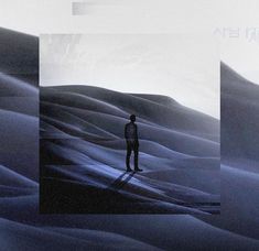 a man standing in the middle of a desert with his shadow on the sand dunes