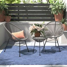 two chairs sitting next to each other on top of a blue rug