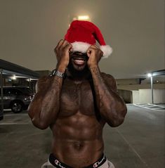 a man with a santa hat on top of his head in a parking lot at night