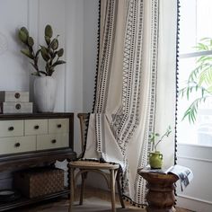 a chair sitting in front of a window next to a table with a potted plant on it