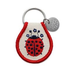 a red and white key chain with a ladybug on it