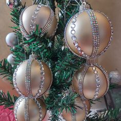 an ornament hanging from a christmas tree with other ornaments on the branches in front of it