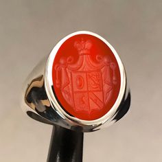 Family crest ring hand-carved on precious stone. This ring was made entirely by hand. Processing can be done on different stones. Please contact me Made to order - 925 sterling silver or 10K - 14K - 18K Solid Gold, signet ring engraved with your university's logo, family crest or any image you request. There is no extra cost for side engravings. ✔Ring Details Gemstone size 12*16mm Metal: 10K Gold, 14K, 18K Gold or 925 Sterling SILVER Please send us a sample image you would like engraved after placing an order. ✈️ Shipping Policy FREE EXPRESS SHIPPING to USA and EU. We use Fedex, TNT, UPS for express shipping. For shipping services, you will be provided with a tracking number. ➡️After the full payment is received, the product will be shipped within 5-7 business days. Fast shipping is delive Fine Jewelry Silver Intaglio Rings, Fine Jewelry Silver Rings With Intaglio, Classic Sterling Silver Intaglio Ring, Heirloom Silver Signet Ring With Intaglio, Carved White Gold Engraved Ring For Formal Occasions, Red Oval Intaglio Ring, Luxury Engraved Ruby Ring, Formal Carved White Gold Engraved Ring, Formal Engraved White Gold Ring