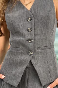 Experience the perfect match to the Denali Pant with our Celina Vest, expertly crafted from soft suiting. Featuring a v-neck, novelty buttons, and a tailored fit, this versatile piece pairs seamlessly with the Denali trousers or your favorite denim. Pair it with the Denali Pant! Fitted V-neck Suits For Work, Fitted Gray Suit For Spring, Spring Gray Workwear Suits, Gray Blazer With Buttons For Work, Spring Gray Suit For Work, Spring Gray Suits For Workwear, Casual Office Suits With Button Closure, Casual Suits With Button Closure For Office, Fitted Gray Blazer For Work