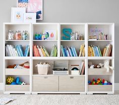 a white bookcase filled with lots of books on top of a carpeted floor