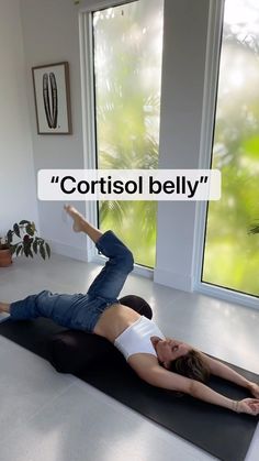 a woman laying on top of a yoga mat with the words cortisol belly above her