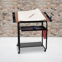 a desk with a paper and pen on it in front of a brick wall,