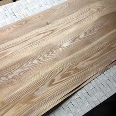 some wood is laying on top of the tile flooring in front of a table