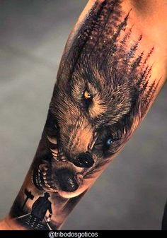 a man's arm with a wolf tattoo on it and his hand holding an object