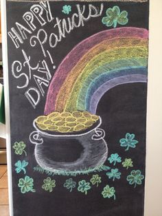 a chalk drawing of a pot of gold with a rainbow and shamrocks on it