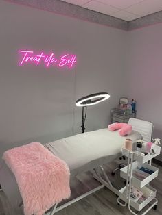 a pink neon sign above a bed in a room