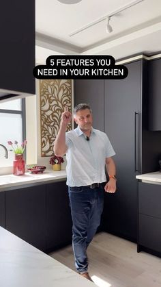 a man walking through a kitchen with the words 5 features you need in your kitchen